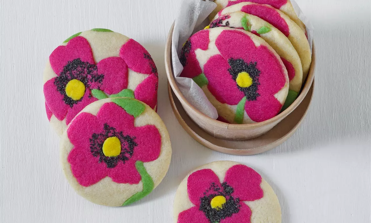 Okrúhle sušienky s motívom vlčích makov na bielom podklade.