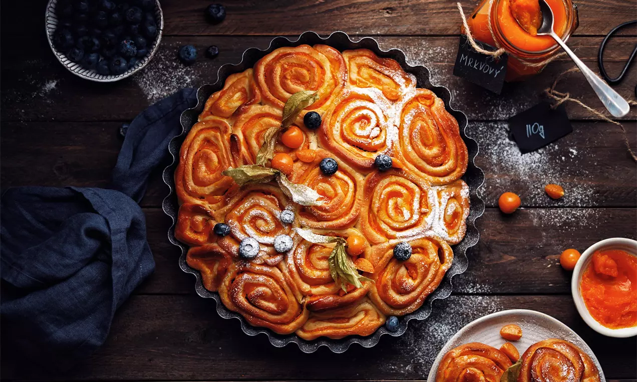 Vosí hnízda zo zlatistého cesta v tvare špirál usporiadané v okrúhlej forme, ozdobené prachovým cukrom, physalis a čučoriedkami
